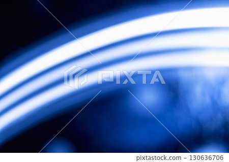 Abstract background featuring glowing line and soft, dark blue bokeh lights. Decorative element suitable for use as a backdrop Abstract background featuring glowing line and soft, dark blue bokeh lights. Decorative element suitable for use as a backdrop 130636706