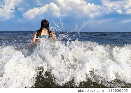 Happy teenager enjoying the ocean waves 130636905