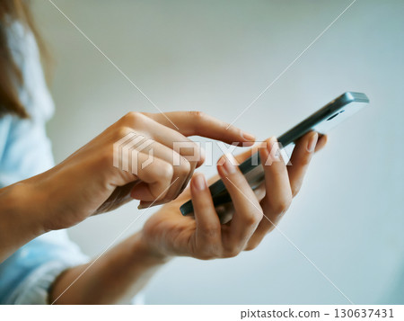 Woman's hand operating a smartphone Generative AI 130637431