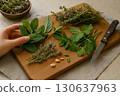 A wooden cutting board with fresh herbs, pine nuts, and a knife, prepared for culinary use. Generated AI. 130637963