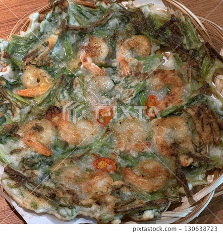Korean savory pancake (Pajeon) with green onions and vegetables, crispy on the edges and tender inside. A popular Korean dish enjoyed with dipping sauce, perfect as a snack or appetizer. Korean savory pancake (Pajeon) with green onions and vegetables, crispy on the edges and tender inside. A popular Korean dish enjoyed with dipping sauce, perfect as a snack or appetizer. 130638723