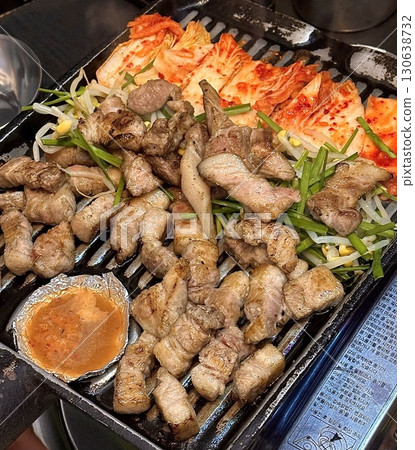 Juicy grilled samgyeopsal paired with spicy, tangy kimchi, offering a perfect harmony of rich, savory meat and bold fermented flavor in every sizzling, mouthwatering bite. Juicy grilled samgyeopsal paired with spicy, tangy kimchi, offering a perfect harmony of rich, savory meat and bold fermented flavor in every sizzling, mouthwatering bite. 130638732