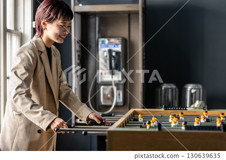 Woman in a room with a tabletop soccer game 130639635