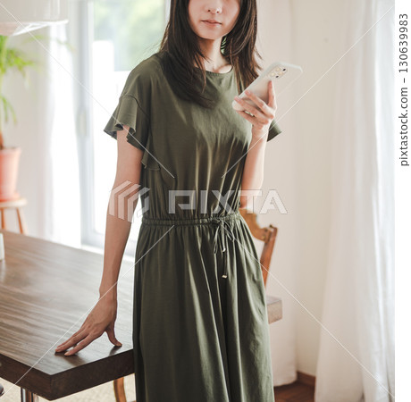 A woman in a dress and a smartphone 130639983