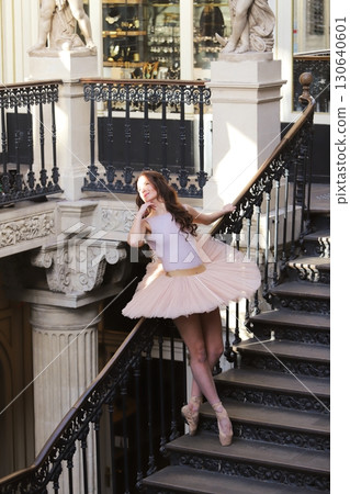 Ballet dancer posing on elegant staircase outdoors Ballet dancer posing on elegant staircase outdoors 130640601