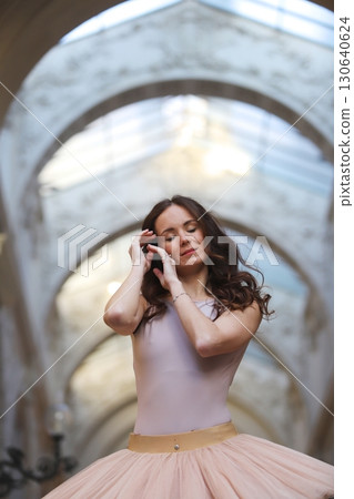Ballet dancer with serene expression under archway 130640624