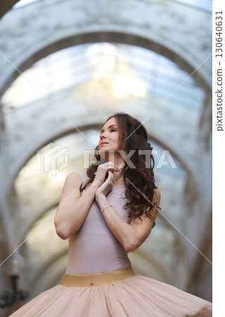 Ballet dancer in graceful pose under stone arch Ballet dancer in graceful pose under stone arch 130640631