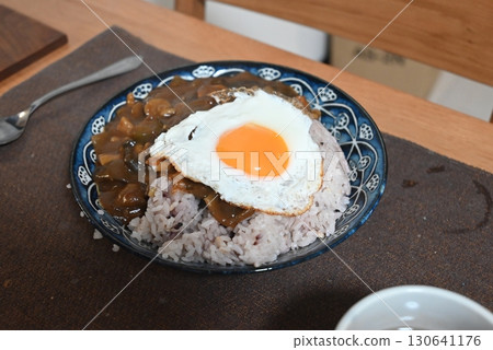 Homemade curry topped with a fried egg Homemade curry topped with a fried egg 130641176