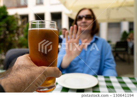Reject a glass of beer, woman refusing alcohol, stop drinking, sobriety concept, saying no to beer glass 130641194