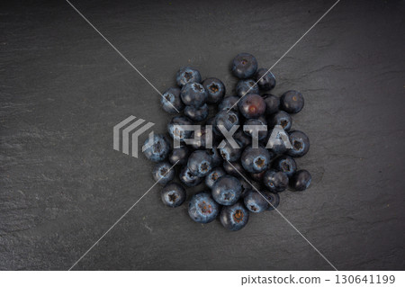 Blueberry on black plate. Fresh blue berry fruits, bilberry group on dark background Blueberry on black plate. Fresh blue berry fruits, bilberry group on dark background 130641199
