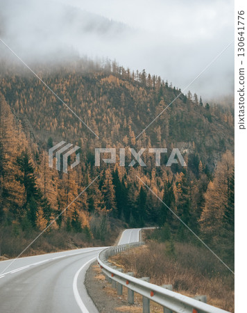 Journey through Altai. Travelling in Mountains. Autumn view of the Altai Mountains, driving by car along the Chuisky Tract highway. Amazing view of mountain road with clouds on mountain tops in Fall 130641776