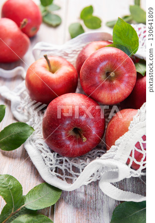 Fresh red apples resting in reusable shopping bag promoting sustainability Fresh red apples resting in reusable shopping bag promoting sustainability 130641809