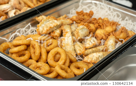 Deep fry seafood set with calamari rings, crispy gyoza dumplings, shrimps and spring rolls 130642134