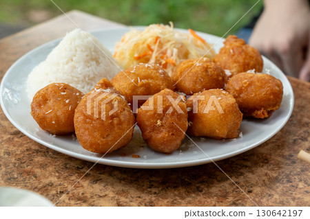 Fried chicken balls with rice and fresh cabbage salad closeup. Deep fried dough balls Fried chicken balls with rice and fresh cabbage salad closeup. Deep fried dough balls 130642197