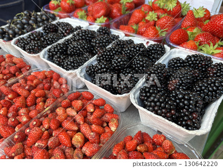 Fruit background with berry mix. Fresh juice blackberries and strawberries in market boxes Fruit background with berry mix. Fresh juice blackberries and strawberries in market boxes 130642220