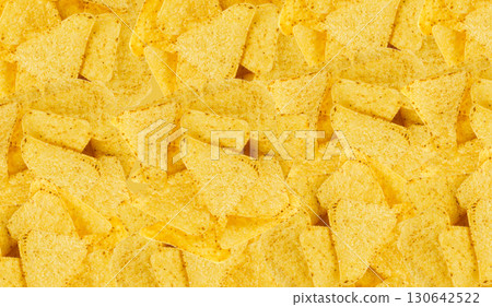 Heap of triangle corn chips pattern, food textured background Heap of triangle corn chips pattern, food textured background 130642522