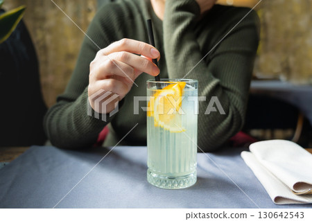 Ice lemonade in tall glass. Yuzu mocktail with lemon and soda, cool lime juice cocktail Ice lemonade in tall glass. Yuzu mocktail with lemon and soda, cool lime juice cocktail 130642543