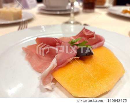 Slices of prosciutto on white plate 130642575