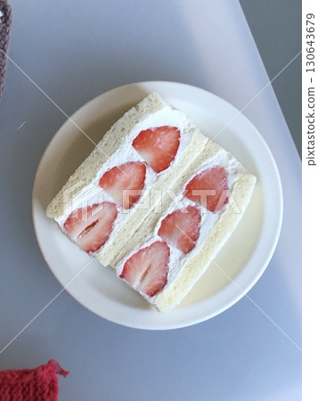 Japanese fruit sando with fluffy white bread, fresh cream, and vibrant slices of seasonal fruits like strawberries, kiwis, and mangoes. A refreshing, colorful treat perfect for any occasion. 130643679