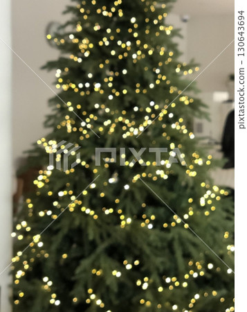 A beautifully decorated Christmas tree with twinkling lights, colorful ornaments, and a star on top. A symbol of warmth and joy, perfect for celebrating the holiday season. 130643694