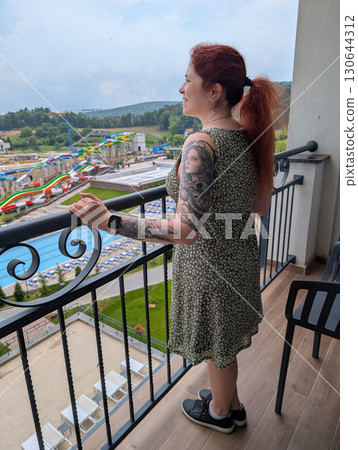 Woman looking out from balcony hotel 130644312