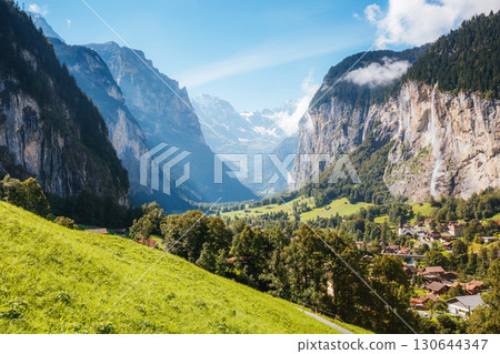 Great view of alpine village glowing by sunlight. Location Swiss alps, Lauterbrunnen valley, Staubbach waterfall, Europe. Great view of alpine village glowing by sunlight. Location Swiss alps, Lauterbrunnen valley, Staubbach waterfall, Europe. 130644347