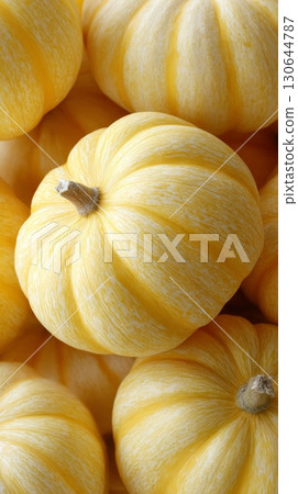 Bright yellow pumpkins are tightly arranged, showcasing their smooth texture and seasonal appeal 130644787