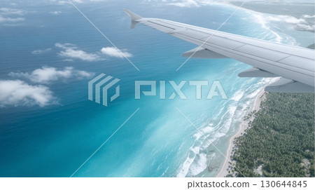 Passengers enjoy breathtaking ocean views from the airplane wing while flying above the coastline 130644845