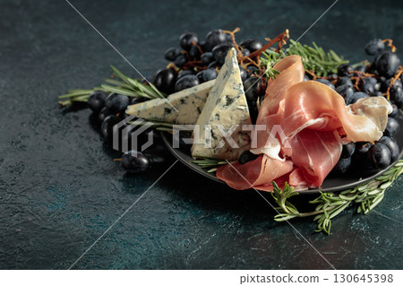 Prosciutto with blue cheese, grapes, and rosemary. Prosciutto with blue cheese, grapes, and rosemary. 130645398