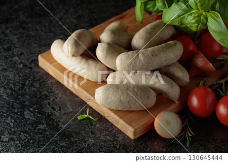 Traditional Bavarian white sausages with basil, onion, rosemary, and tomatoes. Traditional Bavarian white sausages with basil, onion, rosemary, and tomatoes. 130645444