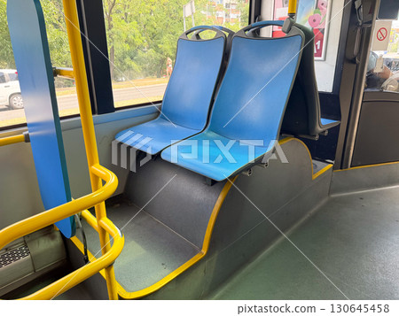 Empty blue seats in a city bus. Public transport, urban mobility, and everyday commuting lifestyle. Empty blue seats in a city bus. Public transport, urban mobility, and everyday commuting lifestyle. 130645458
