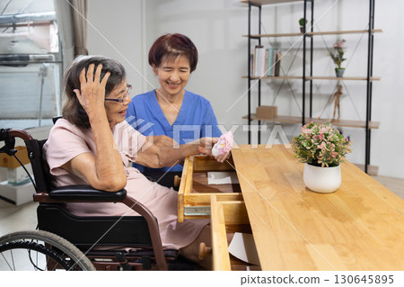 Elderly woman found her lost wallet in drawer. Dementia concept. Elderly woman found her lost wallet in drawer. Dementia concept. 130645895