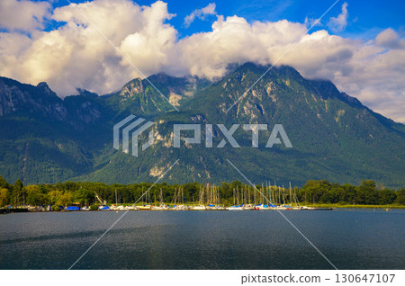 Sailboats at Port de Villeneuve on Lake Geneva with the Swiss Alps rising behind 130647107