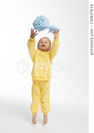 Portrait of beautiful cute little toddler girl. Child with funny face in yellow sweatshirt jumps. Pretty smile kid in studio on white background. High quality photo Portrait of beautiful cute little toddler girl. Child with funny face in yellow sweatshirt jumps. Pretty smile kid in studio on white background. High quality photo 130647619