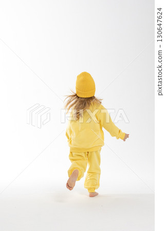 Portrait of beautiful cute little toddler girl. Child with funny face in yellow sweatshirt and hat. Pretty smile kid in studio on white background. High quality photo Portrait of beautiful cute little toddler girl. Child with funny face in yellow sweatshirt and hat. Pretty smile kid in studio on white background. High quality photo 130647624