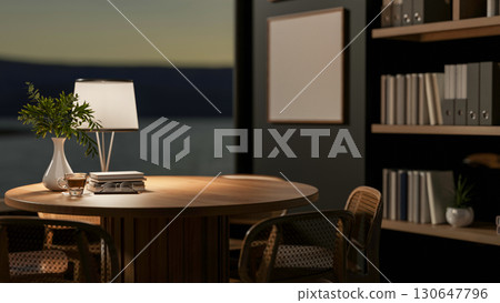 A coffee cup and books on wooden table under a lamp light in dim room. Study or Working at night. 130647796