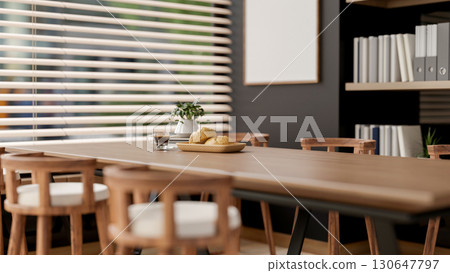 The bread on plate and coffee cup on wooden table with armchairs next to window in office break room 130647797