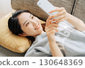 躺在沙發上使用智能手機的女人 130648369