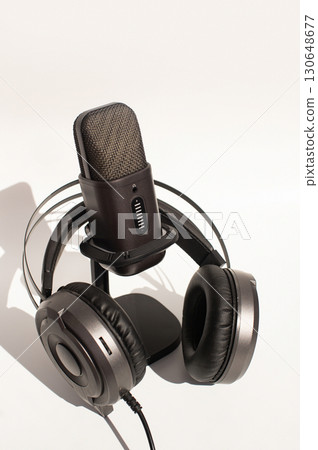 International Podcast Day. Dynamic microphone and headphones set against clean white background 130648677