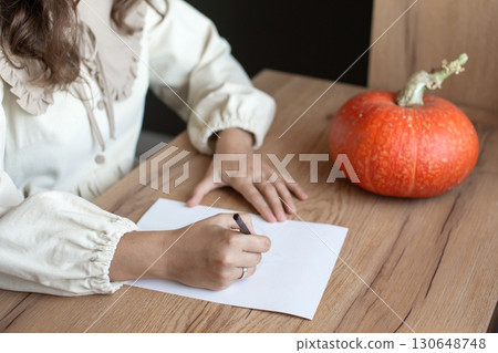 Woman Sketching a Pumpkin by Hand on Paper. Independent Artist Day Woman Sketching a Pumpkin by Hand on Paper. Independent Artist Day 130648748