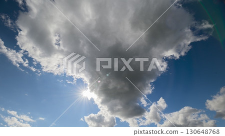 A Cloudy Sky Displaying Beautiful Sunlight Gently Peeking Through the Fluffy Clouds Up Above 130648768