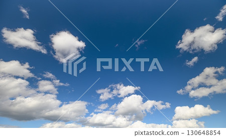 The beautiful blue sky adorned with fluffy white clouds creates a picturesque landscape The beautiful blue sky adorned with fluffy white clouds creates a picturesque landscape 130648854