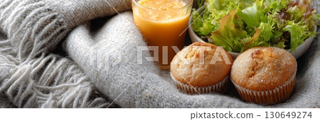 Autumn picnic with pumpkin muffins, fresh salad, and a drink on a soft blanket 130649274