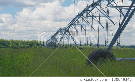 Irrigation System Set Up in a Vibrant Green Field Beneath a Cloudy Sky with Beauty Irrigation System Set Up in a Vibrant Green Field Beneath a Cloudy Sky with Beauty 130649343
