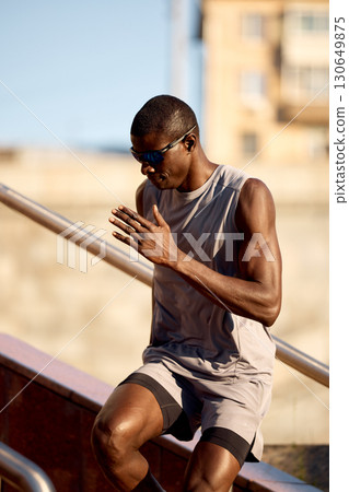 Athletic man running up stairs outdoors for fitness and endurance training 130649875