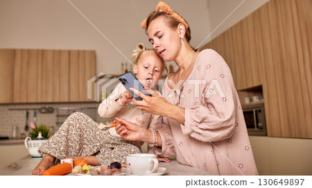 Mother and daughter spending time together in a cozy kitchen environment 130649897