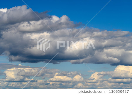 A Dramatic Cloudscape Beneath a Vast Blue Sky With Beautiful Scenery Enhancing the Atmosphere A Dramatic Cloudscape Beneath a Vast Blue Sky With Beautiful Scenery Enhancing the Atmosphere 130650427