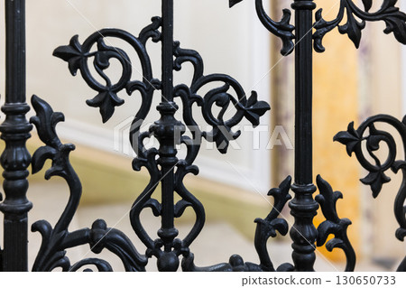 Detailed close-up view of intricate black wrought iron railings design 130650733