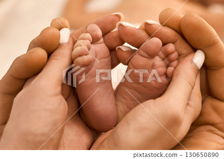 Newborn Baby Feet in Parent's Hands 130650890