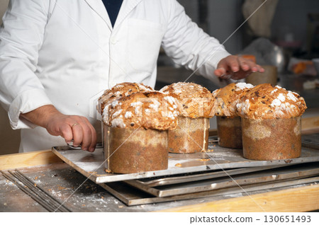 Baker showing a tray with traditional Panettone 130651493